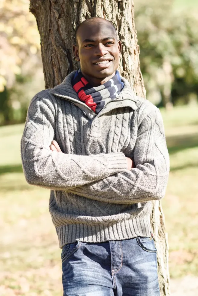 Kenyan man leaning on a tree